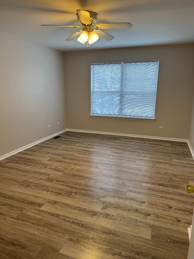 spare room with ceiling fan and dark hardwood / wood-style flooring