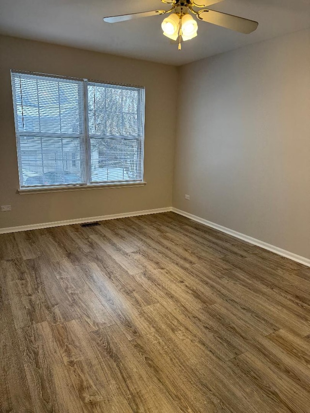 empty room featuring dark hardwood / wood-style flooring and ceiling fan