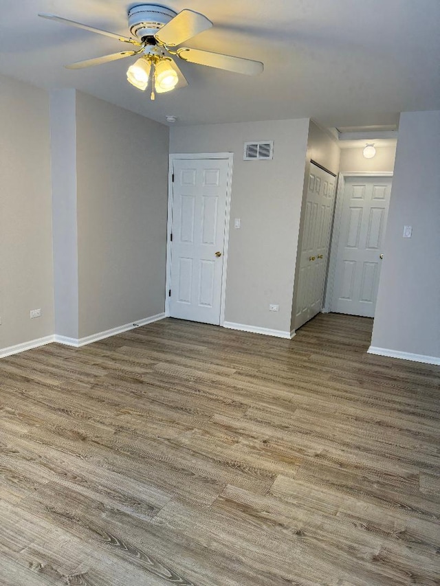 unfurnished room with ceiling fan and wood-type flooring