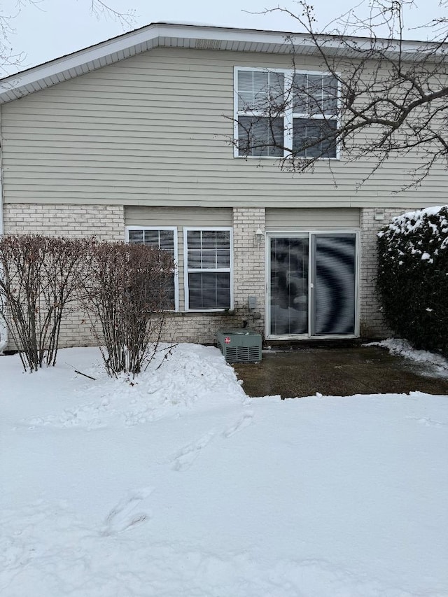 snow covered property featuring cooling unit