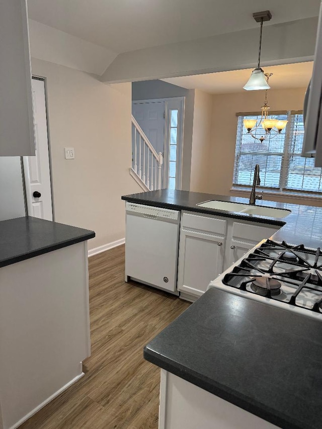 kitchen featuring dishwasher, white cabinetry, sink, hanging light fixtures, and dark wood-type flooring