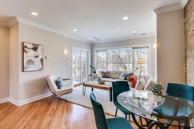 living room featuring crown molding, a wealth of natural light, and light wood-style floors