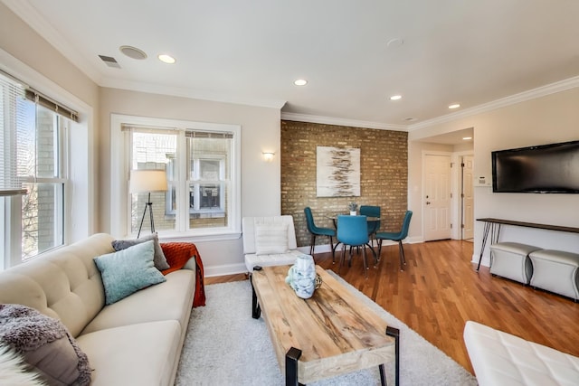 living area with light wood-style flooring, recessed lighting, visible vents, baseboards, and crown molding