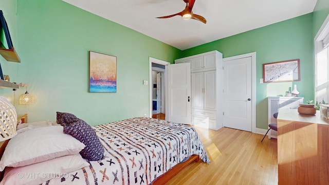 bedroom with a closet, light wood-type flooring, a ceiling fan, and baseboards