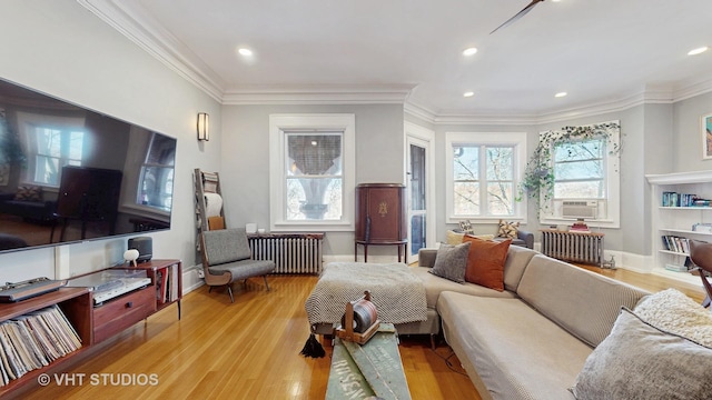 sitting room with ornamental molding, radiator, and wood finished floors