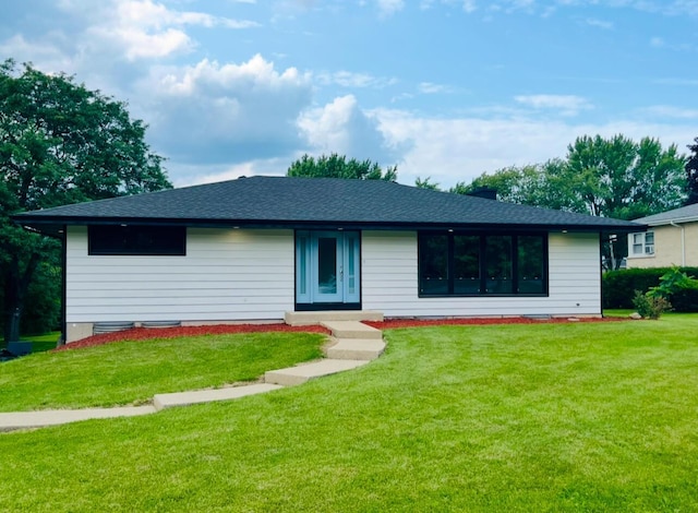 ranch-style home with a shingled roof and a front lawn