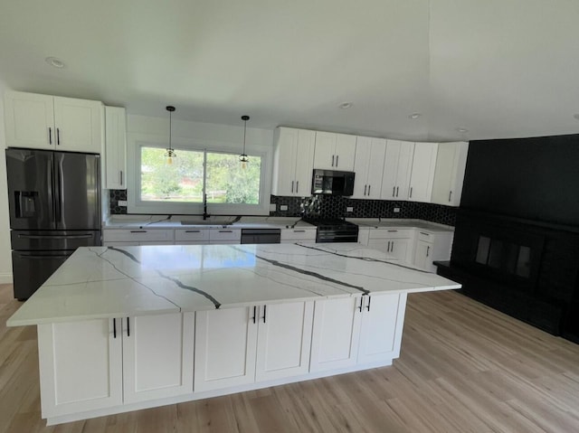 kitchen featuring black appliances, white cabinetry, decorative backsplash, and a sink