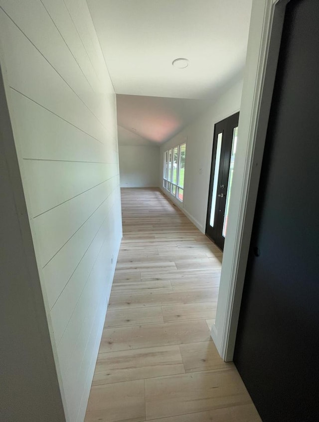 corridor featuring vaulted ceiling and light wood-type flooring