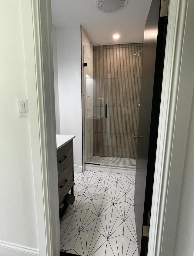 bathroom featuring vanity, tile patterned floors, and a shower with shower door