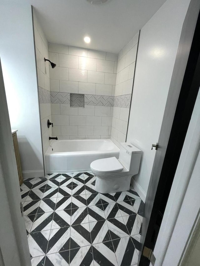 bathroom with tiled shower / bath and toilet