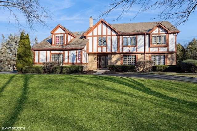 english style home featuring a front lawn