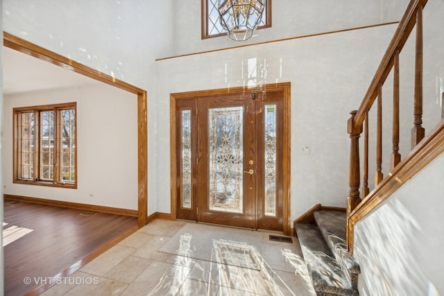 entrance foyer with a healthy amount of sunlight, a high ceiling, and light wood-type flooring