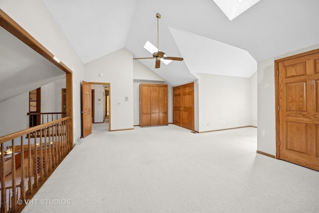 bonus room featuring lofted ceiling with skylight and light colored carpet