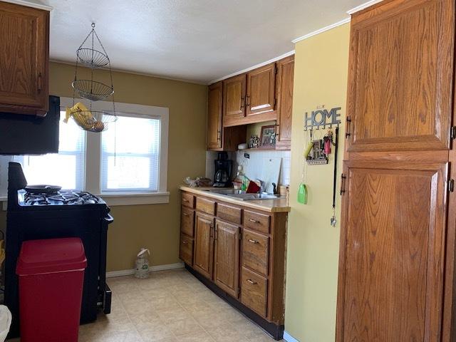 kitchen featuring pendant lighting, sink, and black gas range