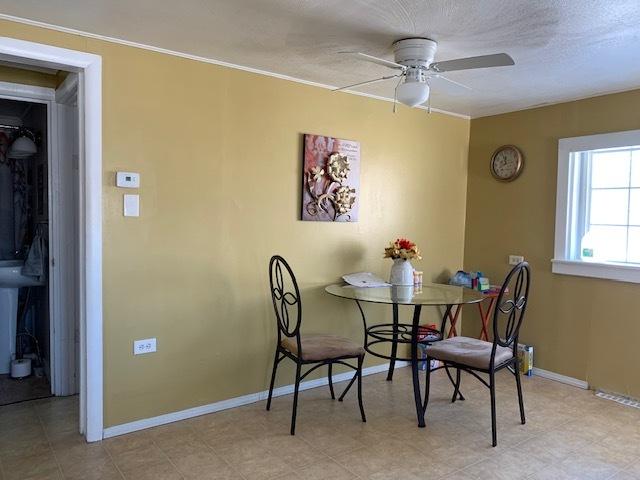 dining space featuring ceiling fan and a textured ceiling