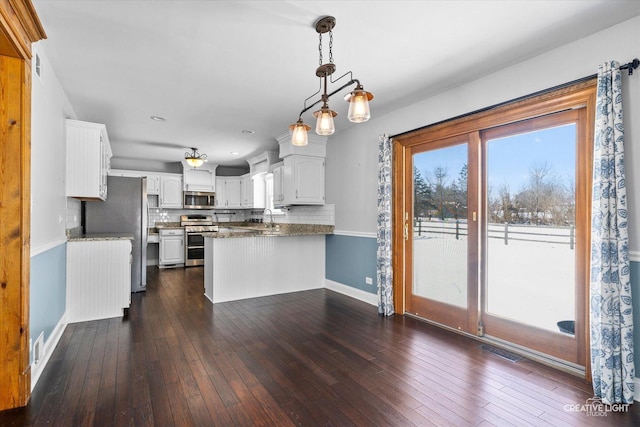 kitchen with white cabinetry, pendant lighting, dark hardwood / wood-style floors, stainless steel appliances, and kitchen peninsula