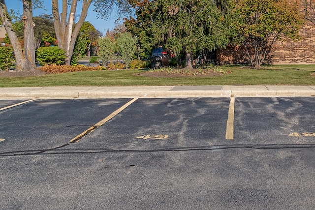 view of parking / parking lot with a lawn