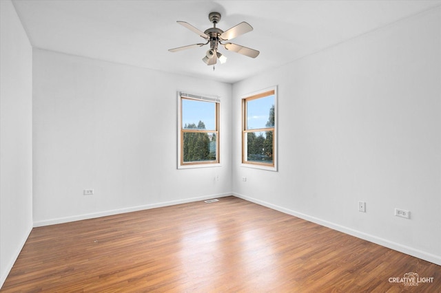 spare room with hardwood / wood-style floors and ceiling fan