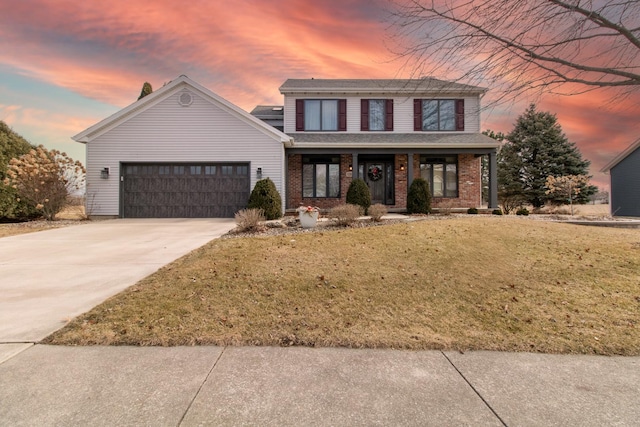 traditional-style house featuring driveway, an attached garage, covered porch, a front lawn, and brick siding