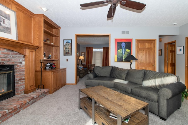 living room with light colored carpet, a fireplace, visible vents, and a textured ceiling