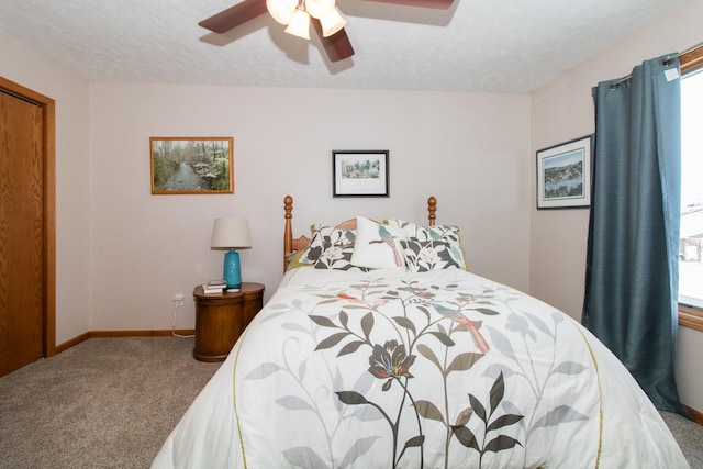 carpeted bedroom with a ceiling fan, baseboards, and a textured ceiling