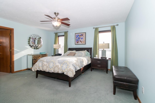 carpeted bedroom featuring multiple windows, baseboards, and ceiling fan