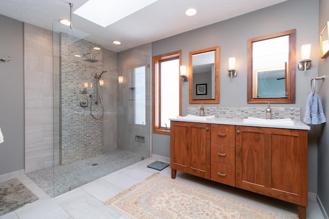 bathroom featuring a sink, a skylight, and walk in shower