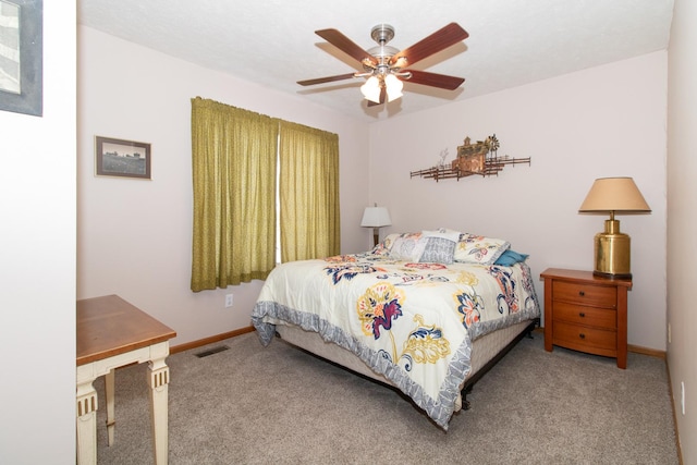 carpeted bedroom with visible vents, baseboards, and ceiling fan