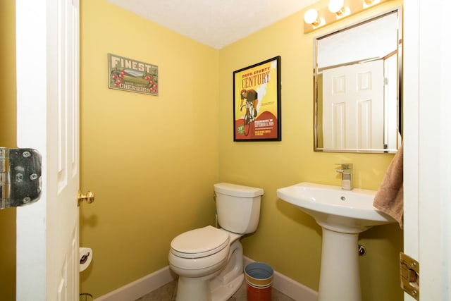 bathroom featuring baseboards and toilet