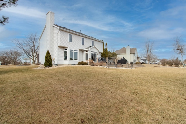 back of property featuring a yard and a chimney