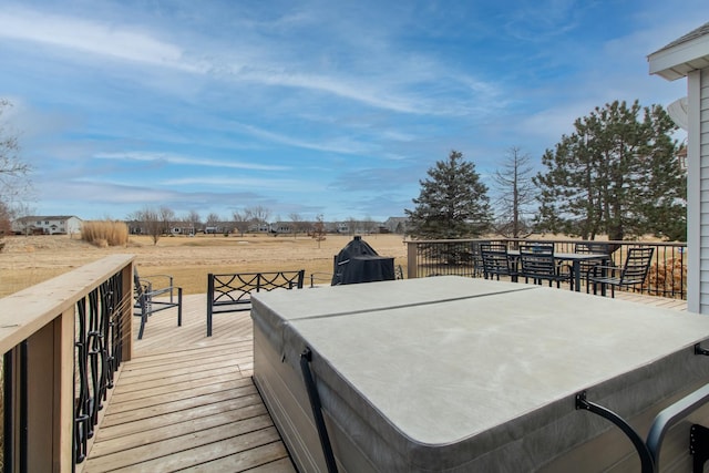 deck featuring a covered hot tub and outdoor dining area