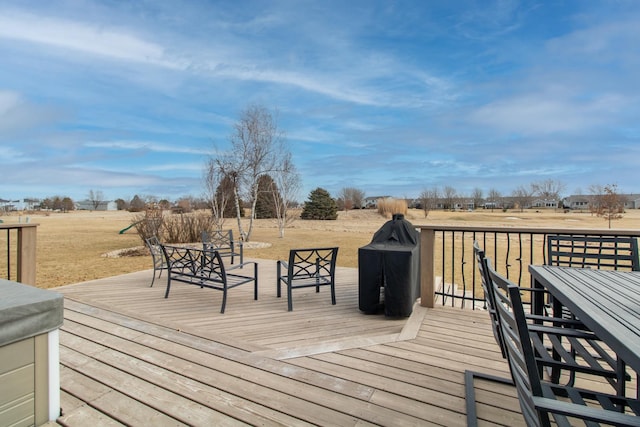 wooden terrace with outdoor dining area and a rural view