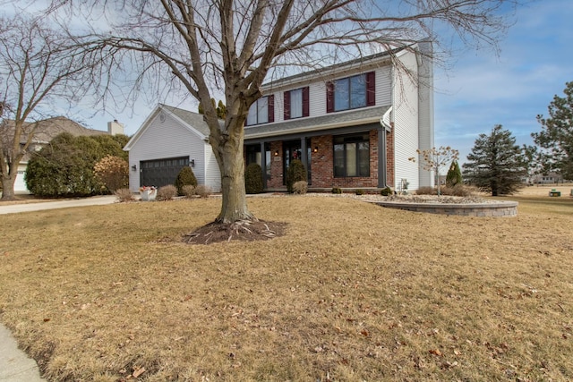 traditional home with a front lawn, an attached garage, brick siding, and a chimney