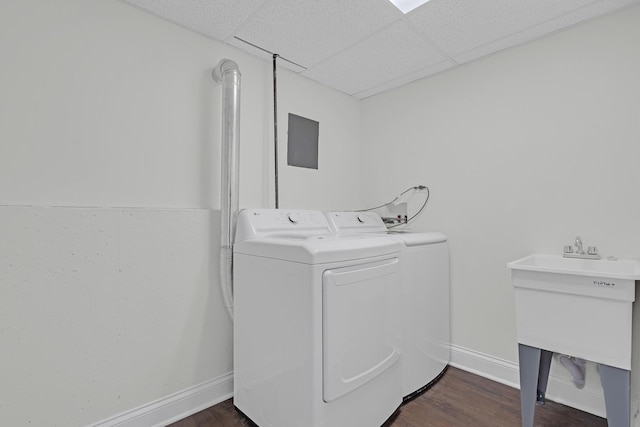 clothes washing area with separate washer and dryer, sink, and dark hardwood / wood-style flooring