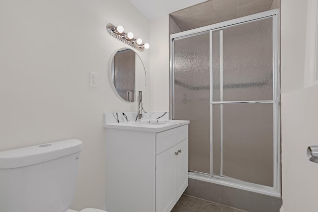 bathroom with vanity, toilet, an enclosed shower, and tile patterned flooring