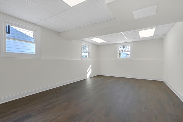 basement with a drop ceiling and dark hardwood / wood-style floors