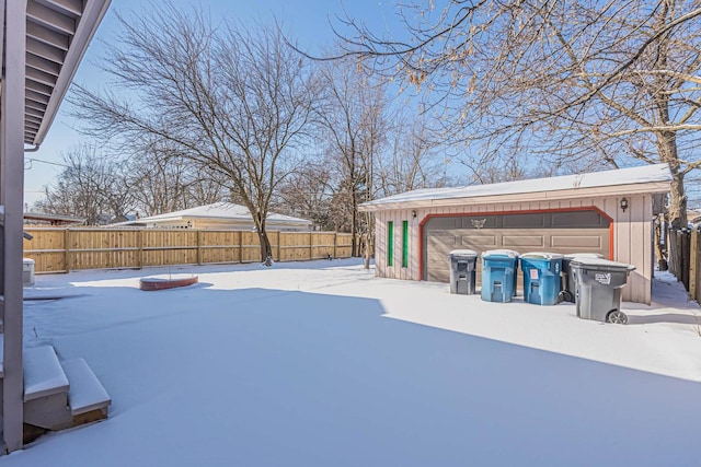 yard covered in snow featuring a garage and an outdoor structure