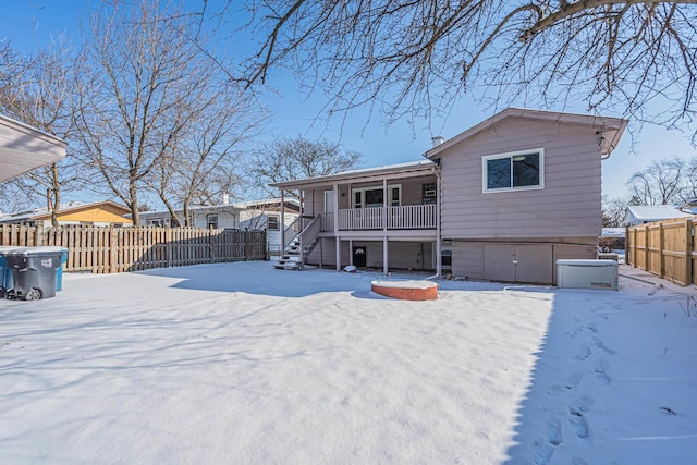 snow covered house featuring a porch