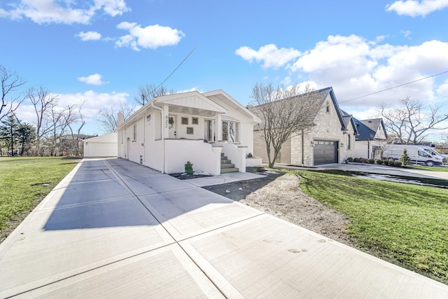 view of front of house with stone siding, a detached garage, a chimney, and a front lawn