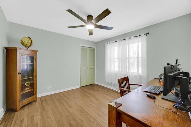 office area with light wood finished floors, baseboards, and a ceiling fan