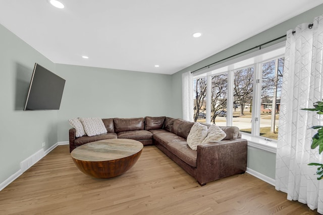 living room featuring light wood-style floors, recessed lighting, visible vents, and baseboards