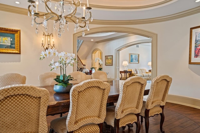 dining room with ornamental molding, arched walkways, hardwood / wood-style floors, and baseboards