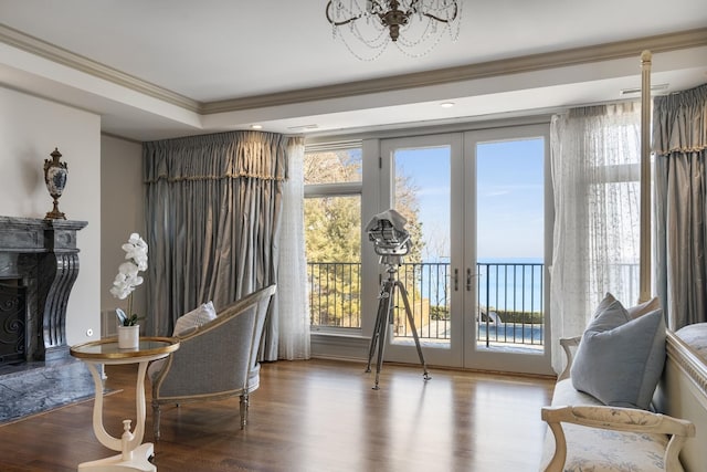 sitting room with french doors, crown molding, a water view, a high end fireplace, and wood finished floors