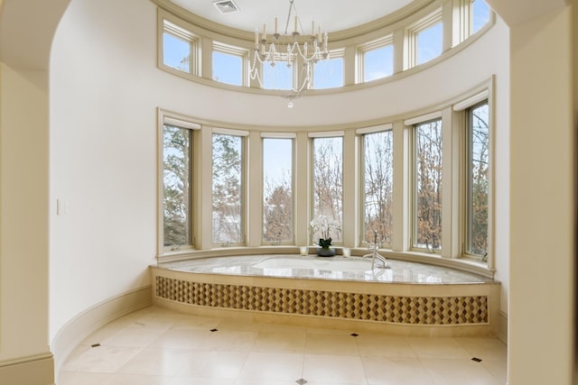 bathroom with visible vents, a high ceiling, a wealth of natural light, and an inviting chandelier