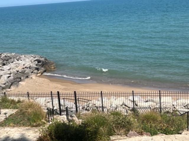 property view of water featuring fence and a view of the beach