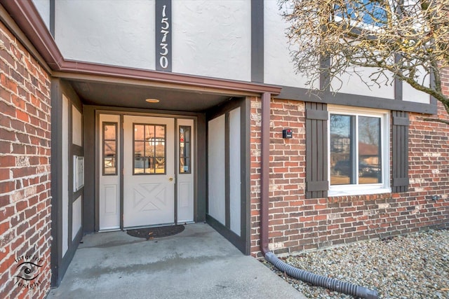 entrance to property featuring brick siding