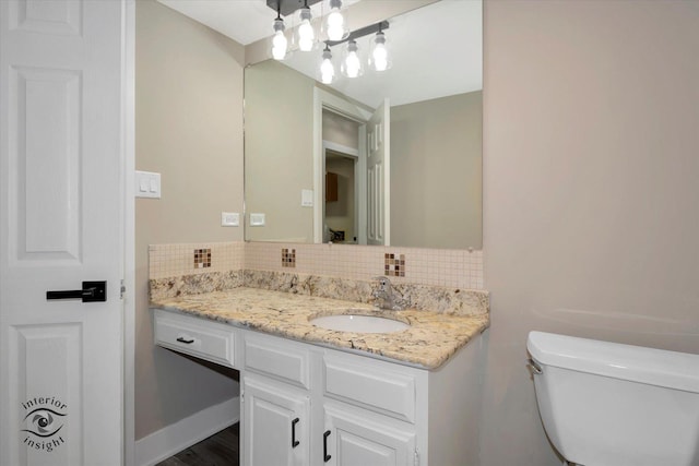 bathroom featuring backsplash, toilet, and vanity