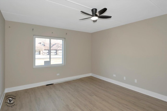 empty room with visible vents, baseboards, light wood-type flooring, and ceiling fan