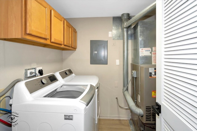 clothes washing area featuring baseboards, electric panel, light wood-style flooring, cabinet space, and independent washer and dryer