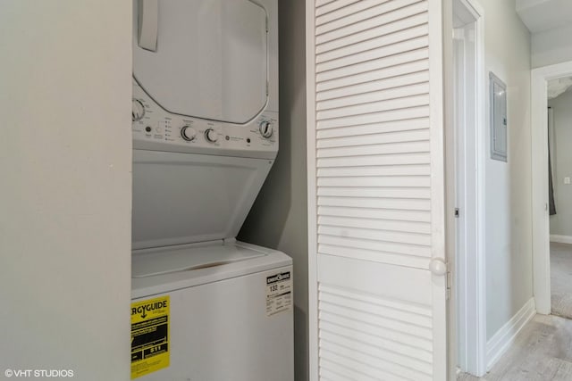 laundry room with stacked washer / drying machine and light hardwood / wood-style flooring